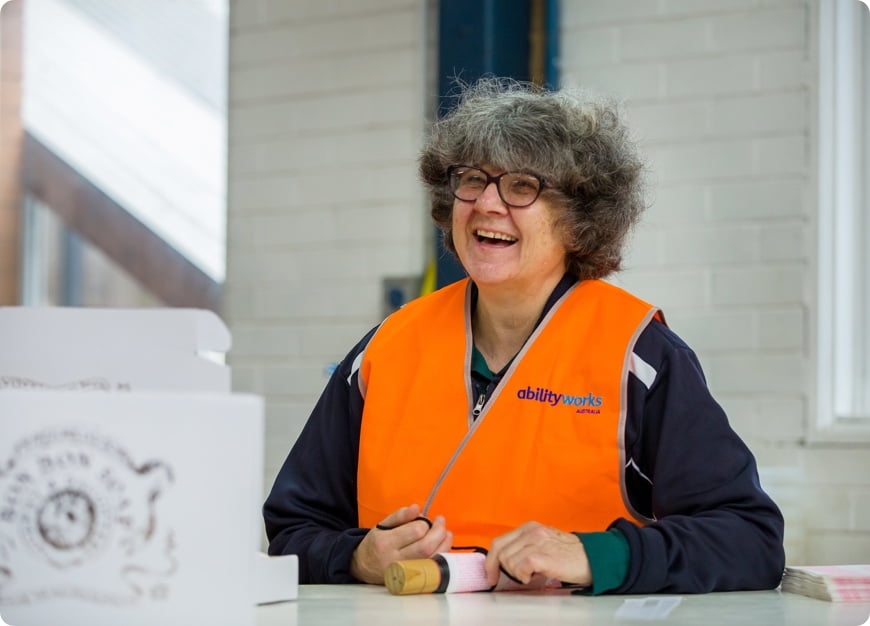 a very happy employee, smiling as she works on one of our packing and assembly jobs